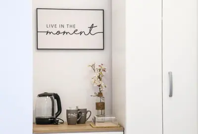 a living room with a picture of live in the moment at MaNora in Ulcinj