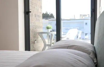 a bed in a room with a view of a patio at MaNora in Ulcinj