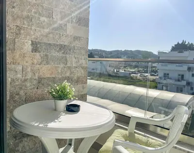 a white table and two chairs on a balcony at MaNora in Ulcinj