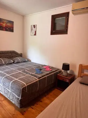 a bedroom with a bed and a table with a lamp at Vikendica Nina in Čanj