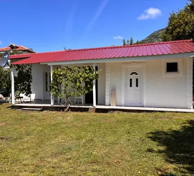 a small white house with a red roof at Vikendica Nina in Čanj