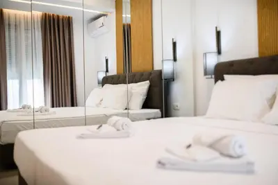 a hotel room with two beds and a mirror at G Star Hotel in Sutomore
