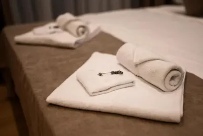 two towels on top of a bed with a robe at G Star Hotel in Sutomore