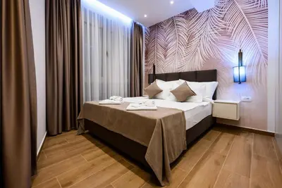 a bedroom with a large bed with a purple wall at G Star Hotel in Sutomore