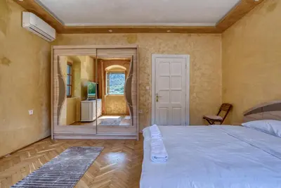 a bedroom with a large bed and a mirror at Stone Home Kotor in Dobrota