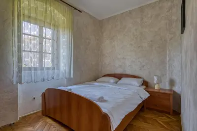 a bedroom with a large bed with a window at Stone Home Kotor in Dobrota