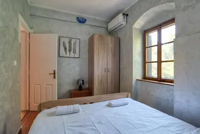 a bedroom with a bed with two towels on it at Stone Home Kotor in Dobrota