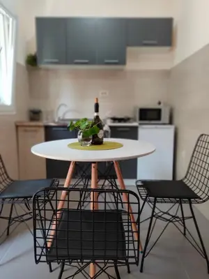 a table with chairs and a bottle of wine on it in a kitchen at Studio Apartman Rea in Kotor