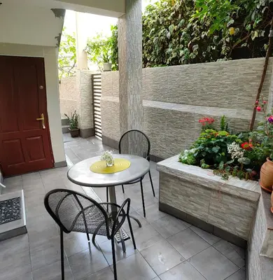 a patio with a table and two chairs and flowers at Studio Apartman Rea in Kotor