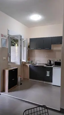 a kitchen with black and white appliances and a window at Studio Apartman Rea in Kotor
