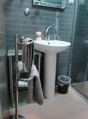 a bathroom with a sink and a shower and a towel at Studio Apartman Rea in Kotor