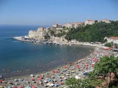 a beach filled with lots of umbrellas and people at Room Rada in Ulcinj