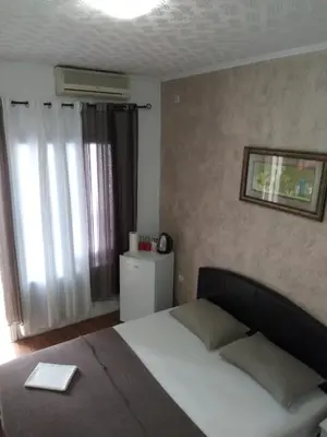 a bedroom with a large bed and a window at Room Rada in Ulcinj