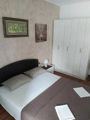 a bedroom with a large bed and white cabinets at Room Rada in Ulcinj