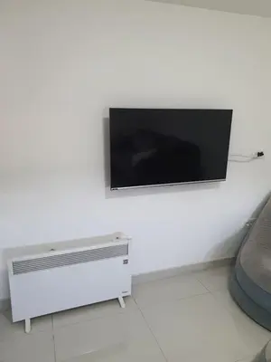 a flat screen tv hanging on a white wall at Apartman Tolosi 2 in Podgorica