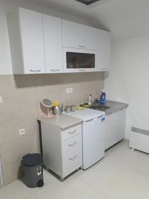 a kitchen with white cabinets and a counter top at Apartman Tolosi 2 in Podgorica
