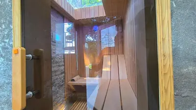 a glass door with a wooden bench in a room at House in the pines in Sutomore