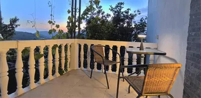 a balcony with a table and chairs and a window at House in the pines in Sutomore