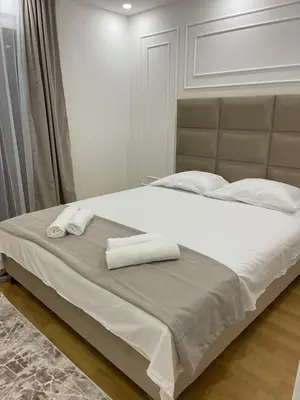 a bed with two towels on top of it at Days Inn Long Beach in Ulcinj