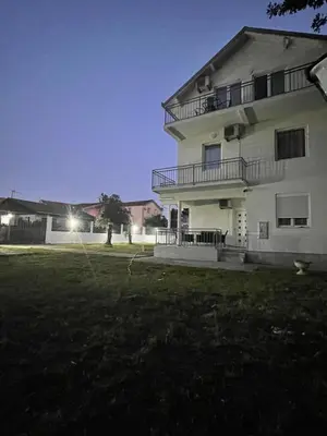a large white building with a yard in front of it at Days Inn Long Beach in Ulcinj