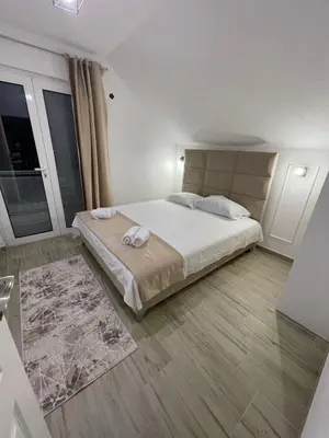 a white bedroom with a large bed and a window at Days Inn Long Beach in Ulcinj