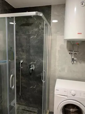 a shower in a bathroom with a washing machine at Apartman A1 in Ulcinj