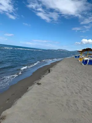 a beach with chairs and umbrellas and the ocean at Apartman A1 in Ulcinj
