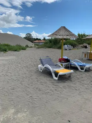 two lounge chairs and an umbrella on a beach at Apartman A1 in Ulcinj