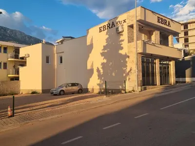 a car parked in front of a building on a street at Ebra Lux Apartmani in Dobra Voda