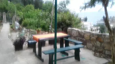 a table and benches in front of a window at Holiday home Panorama in Sutomore