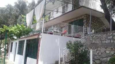 a white house with a balcony on top of it at Holiday home Panorama in Sutomore