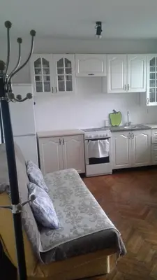 a kitchen with white cabinets and a bed in it at Holiday home Panorama in Sutomore