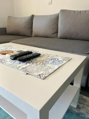 a white coffee table with two remote controls on it at GRAMISI apartments in Kruče