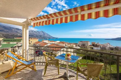 a balcony with a table and chairs and a view of the ocean at D & S Family Apartments Budva in Budva