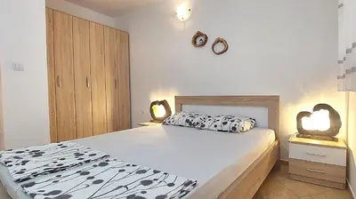 a bedroom with a bed and two lights on the wall at D & S Family Apartments Budva in Budva