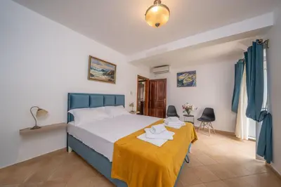 a bedroom with a bed with a yellow blanket on it at Dobrota Blue in Kotor