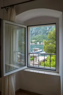 a window with a view of a body of water at Dobrota Blue in Kotor