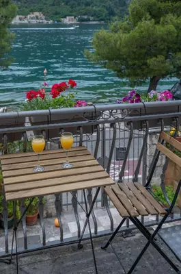 two glasses of orange juice sitting on a wooden table at Dobrota Blue in Kotor