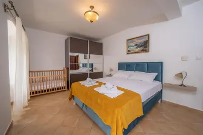 a bedroom with a large bed with a yellow blanket at Dobrota Blue in Kotor