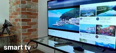 a large screen computer monitor sitting on a glass table at Ric Apartment Budva in Budva