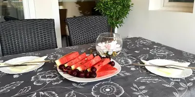 a table with a plate of fruit and a glass of wine at Ric Apartment Budva in Budva