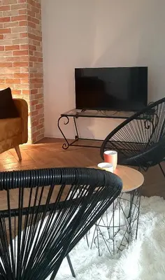 a living room with a black bench and a table at Ric Apartment Budva in Budva