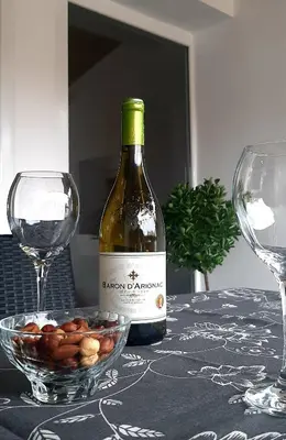 a bottle of wine and a bowl of almonds on a table at Ric Apartment Budva in Budva
