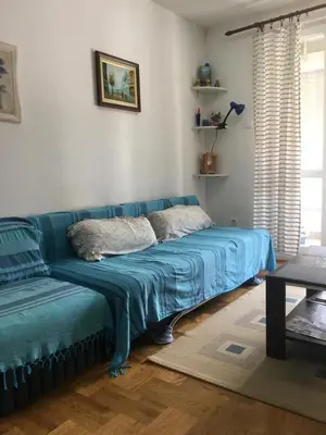 a blue couch in a living room with a window at Bolux Studio Apartment in Budva