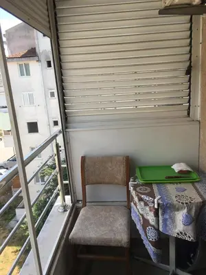 a table and a chair with a laptop on a balcony at Bolux Studio Apartment in Budva