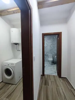 a bathroom with a toilet and a washer and dryer at Holiday home N&S in Bar