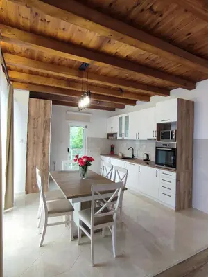 a kitchen with a wooden dining table and chairs at Holiday home N&S in Bar