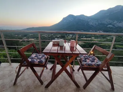 a wooden table and chairs on a balcony with a view at Holiday home N&S in Bar