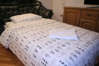 a bed with a white comforter on top of it at Spacious 2Bedroom Flat Budva Becici in Boreti