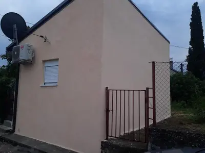 a building with a gate and a window and a satellite at Ljubovic apartman in Podgorica